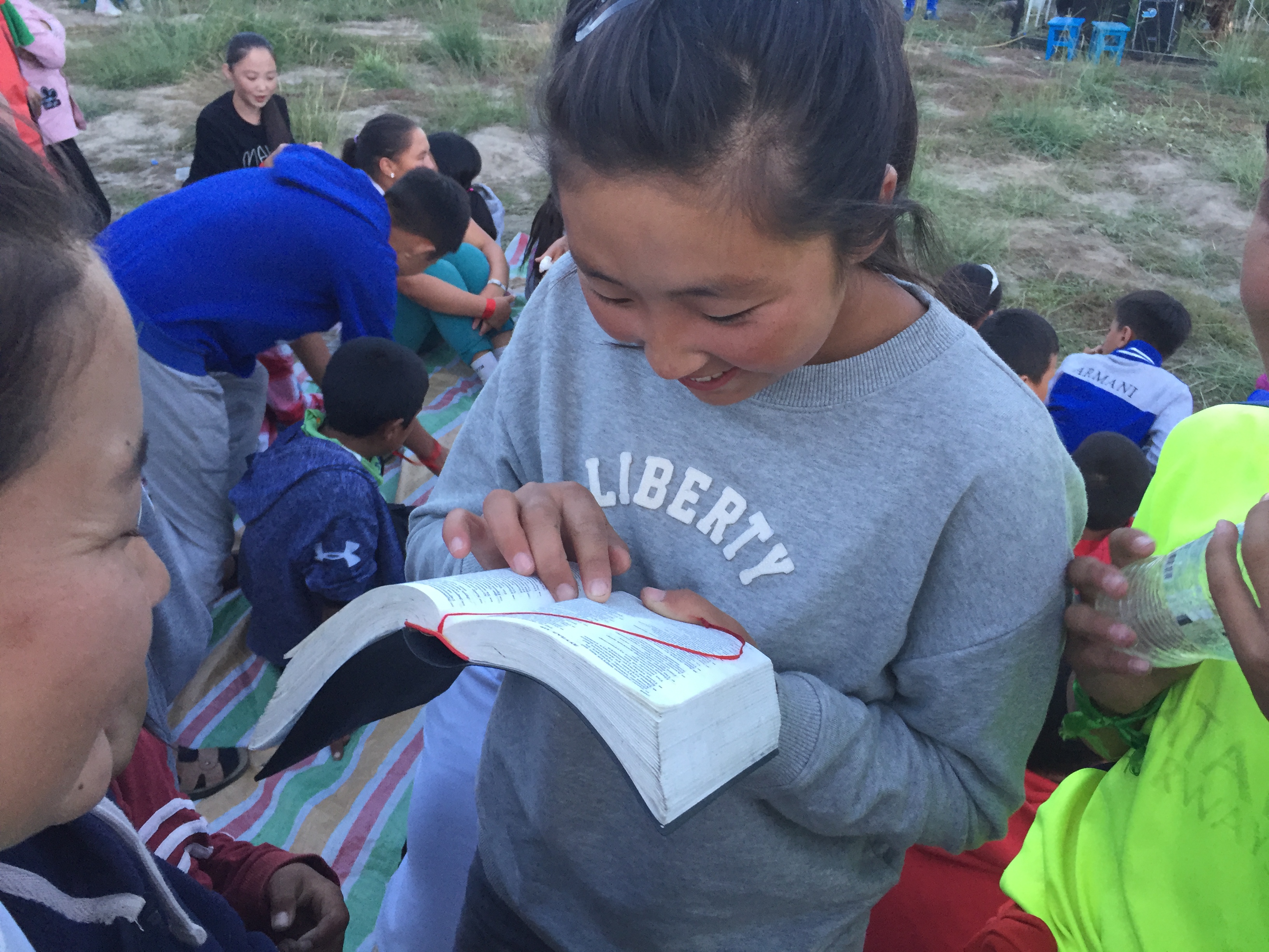Camp in Mongolia 14 Young girl reading the Bible at a summer Bible camp in Mongolia