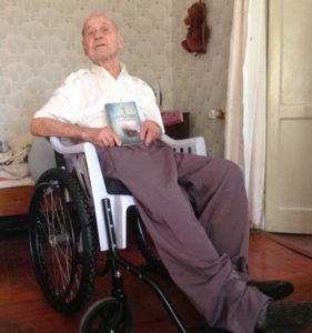 Elderly Ukrainian man with Scripture and a wheelchair